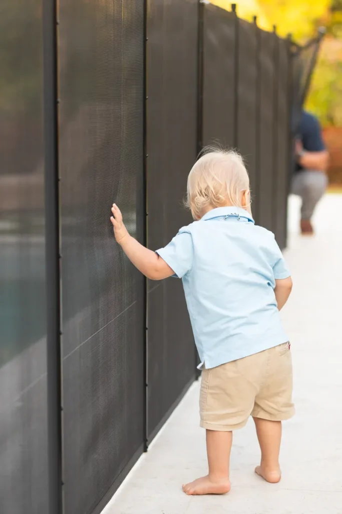 Toddler holding the pool fence palm beach gardens